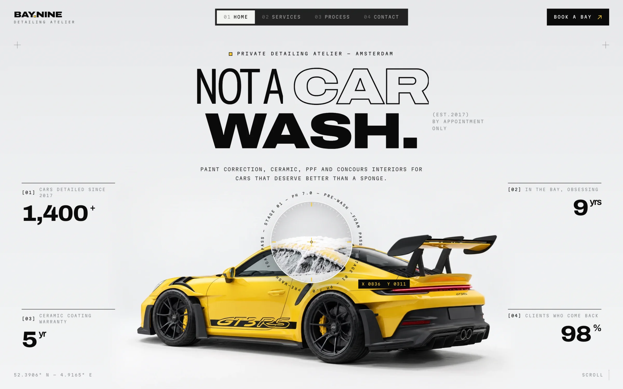 Bay.Nine home page: “Not a car wash.” above a yellow sports car, with the inspection lens open over it